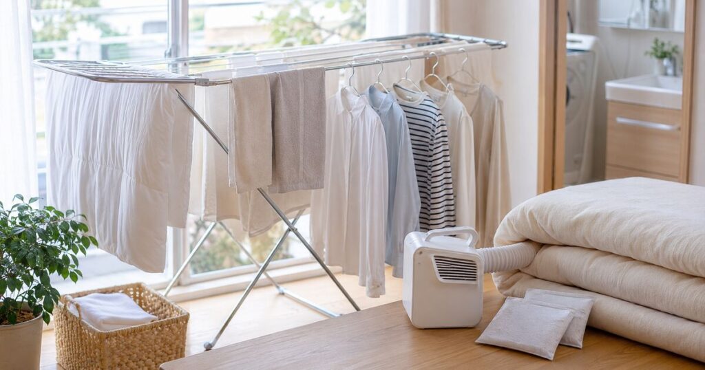 窓際で服やシーツを乾かし毛布を整えている室内